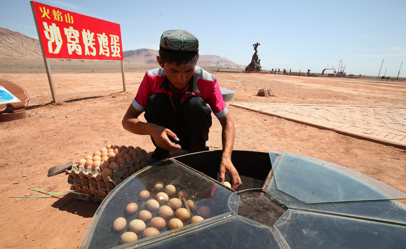 新疆火焰山72℃高温 游客直接烤熟鸡蛋吃 